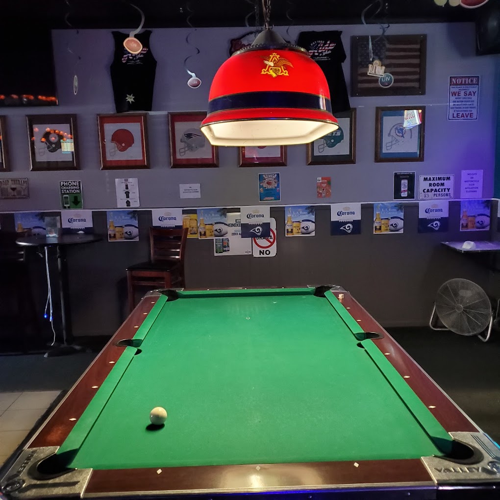 a pool table inside the bar with some lighting